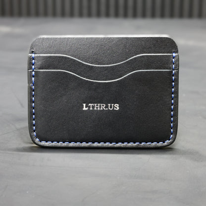 The Townsend card wallet in Black with blue contrast stitching, front