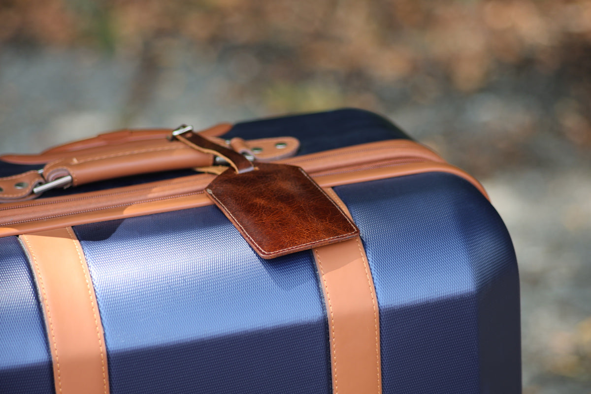 The Detroiter luggage tag in Brown on a suitcase