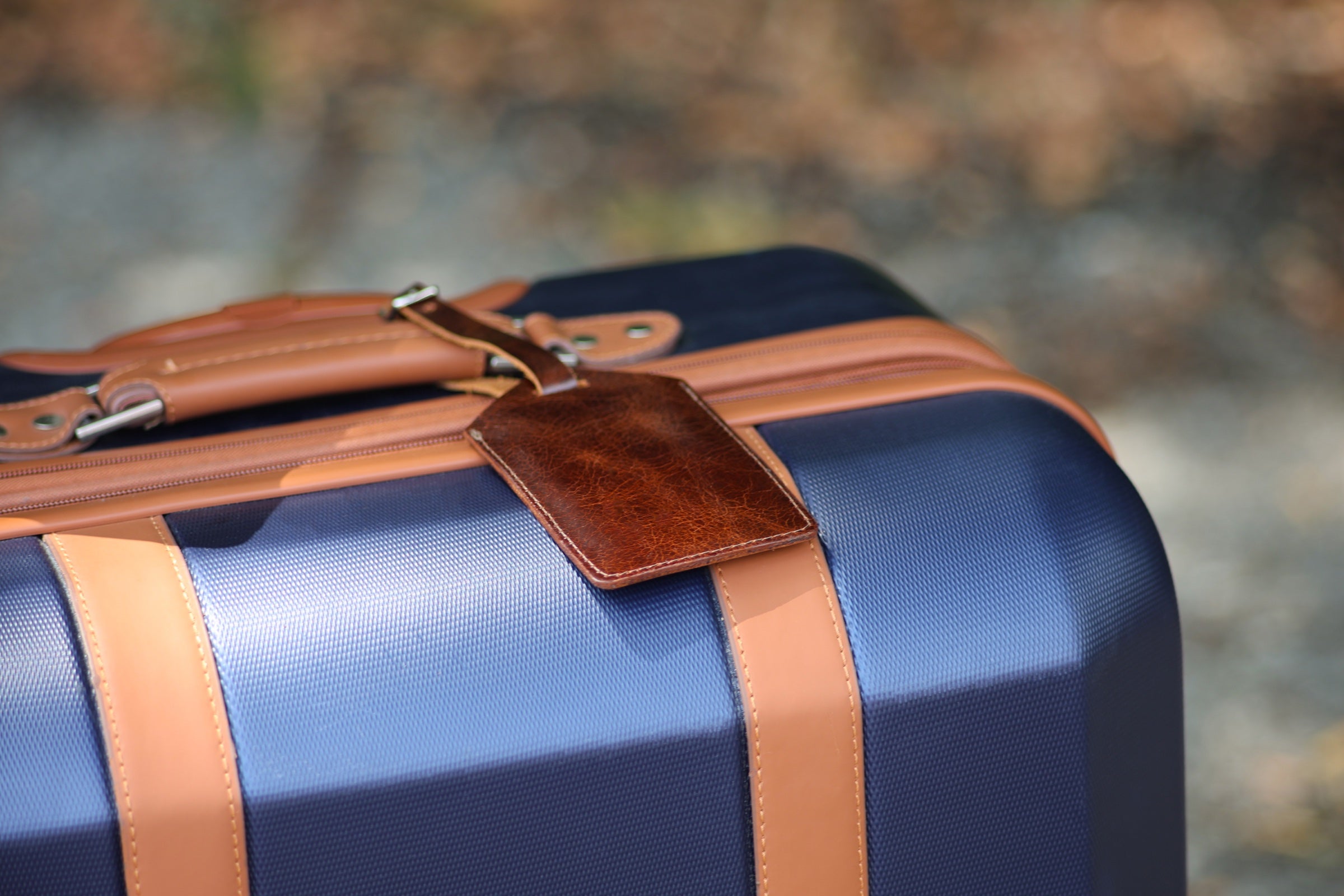 The Detroiter luggage tag in Antique Brown on a suitcase