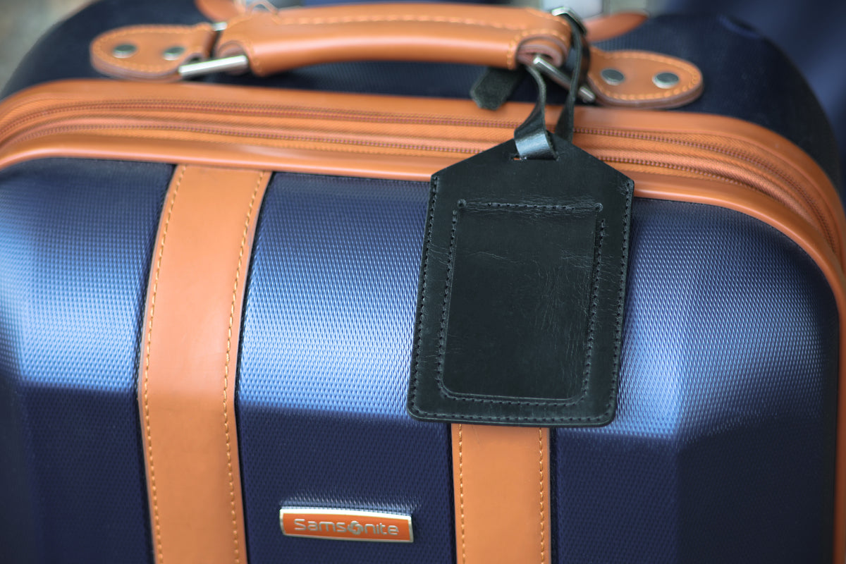 The Detroiter luggage tag in Black on a suitcase